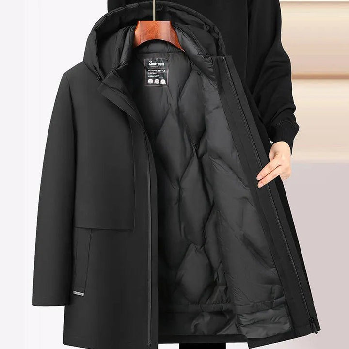 Black winter coat on a hanger with a neutral background
